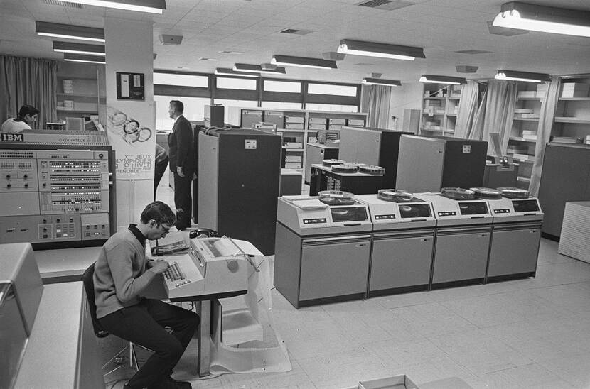Kantoorruimte met een mainframe van IBM in 1968, in grote kasten met een ronde spoel er op